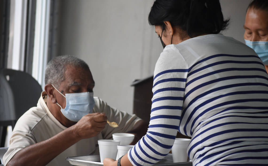 Mujer atendiendo a un adulto mayor
