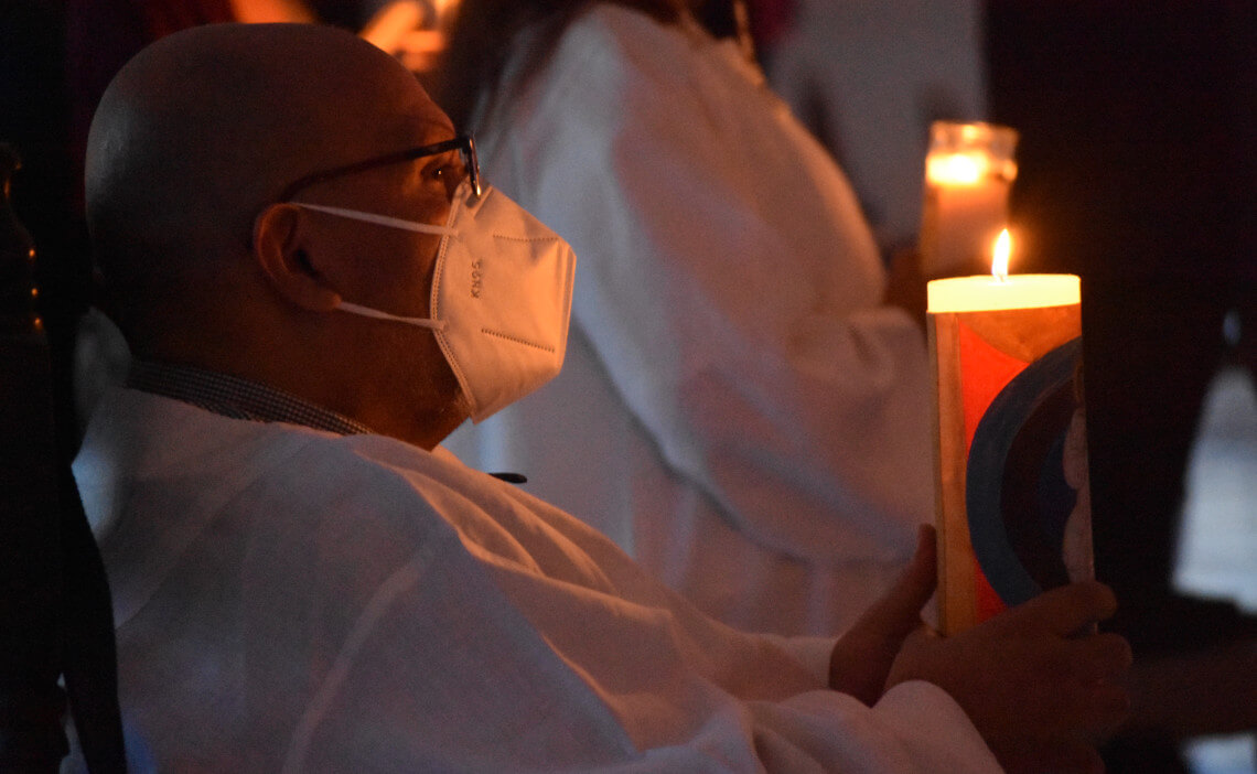 Persona sosteniendo una vela encendida en la oscuridad